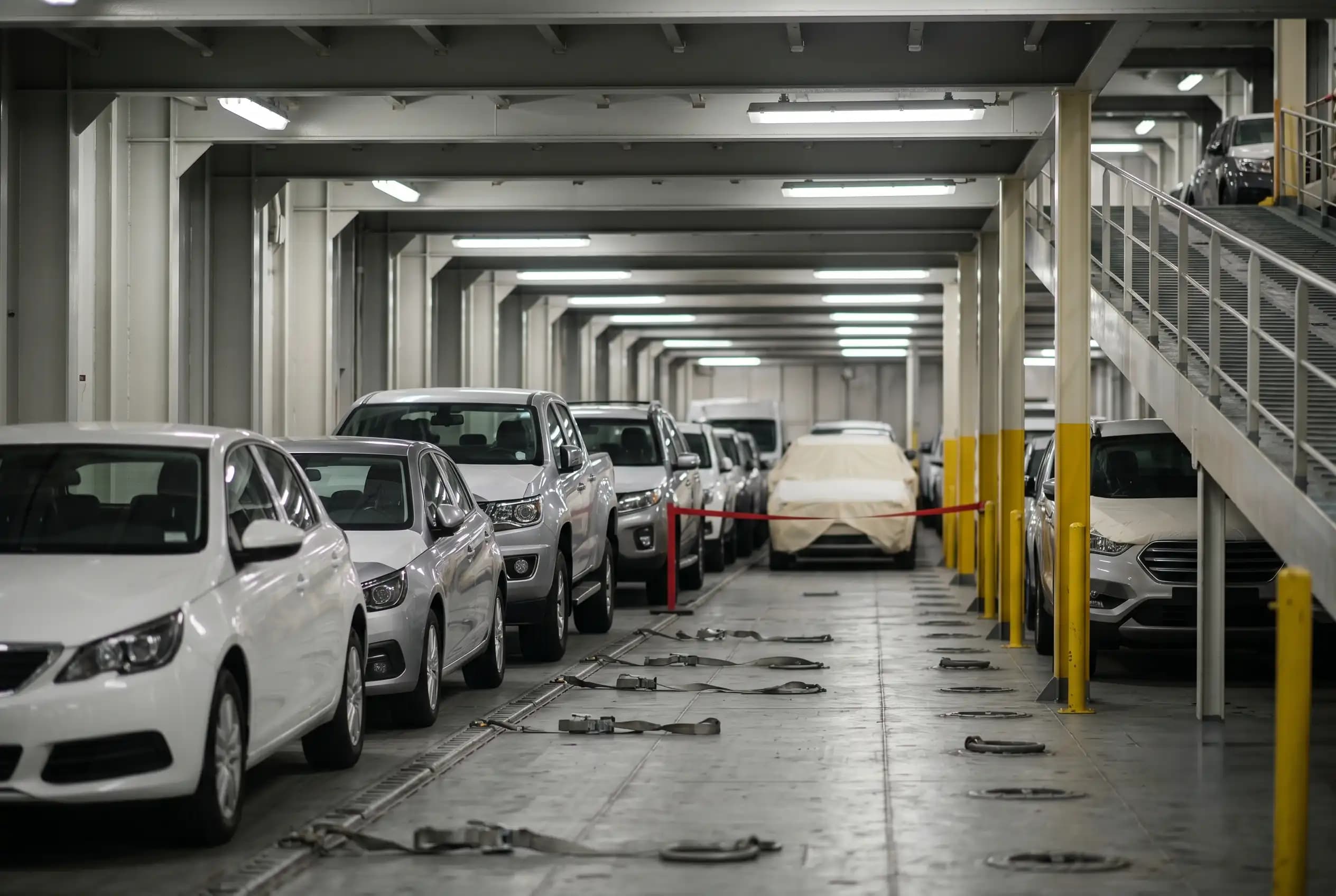 Vehicles being loaded onto the enclosed deck of a roll-on/roll-off vessel bound for Honolulu